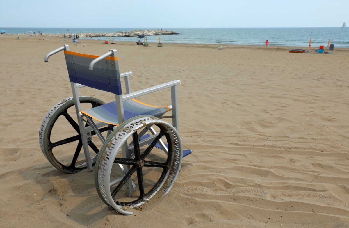 Sedia a rotelle vuota sulla spiaggia