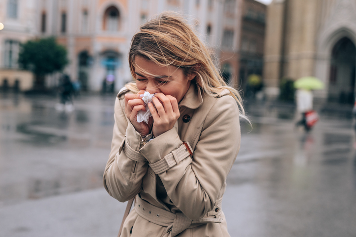 Tempo autunnale e una donna che si pulisce il naso