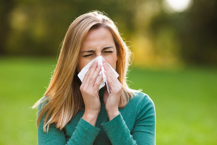 Rinite allergica non infettiva, la donna all'esterno ha il raffreddore, starnutisce