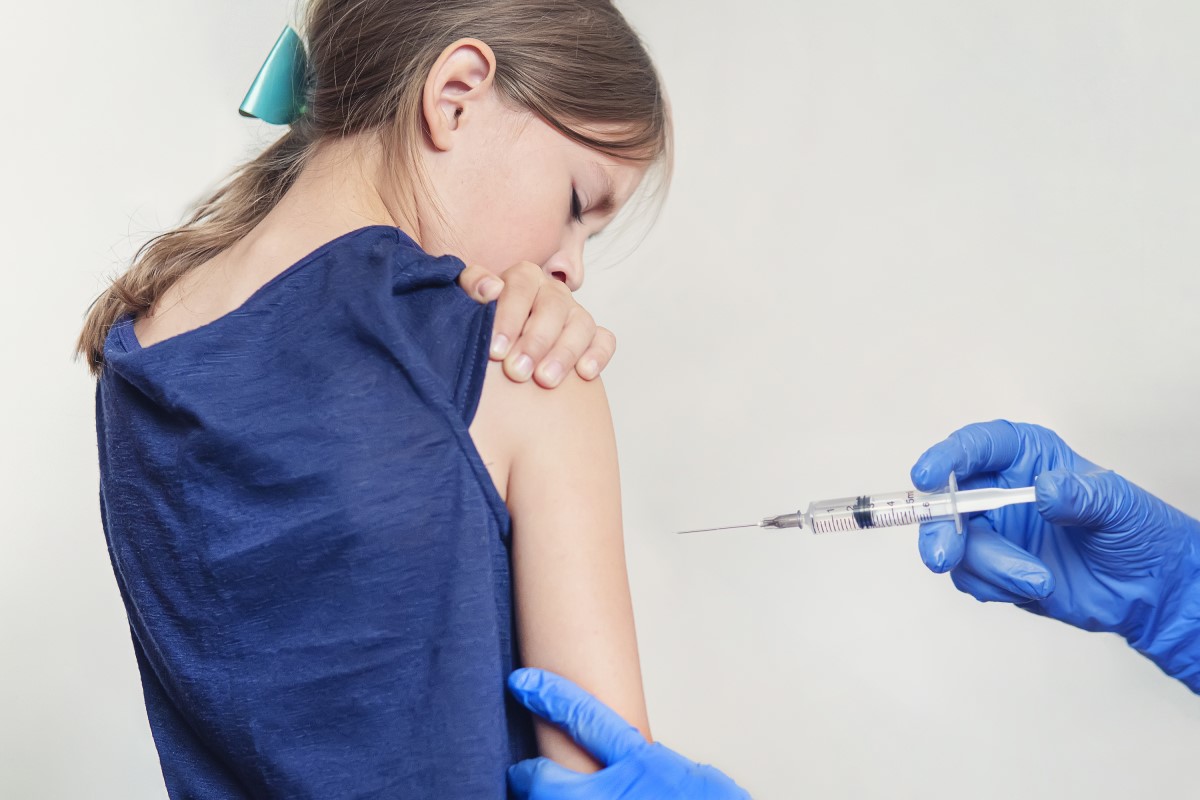 Vaccinazione di un bambino - ragazze - il medico inietta il vaccino nella spalla