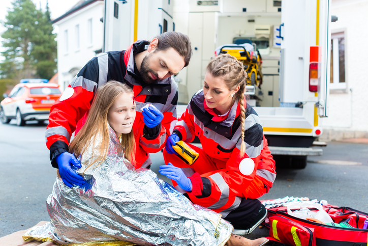 La ragazza con la ferita è coperta da una pellicola isotermica che impedisce la perdita di calore.