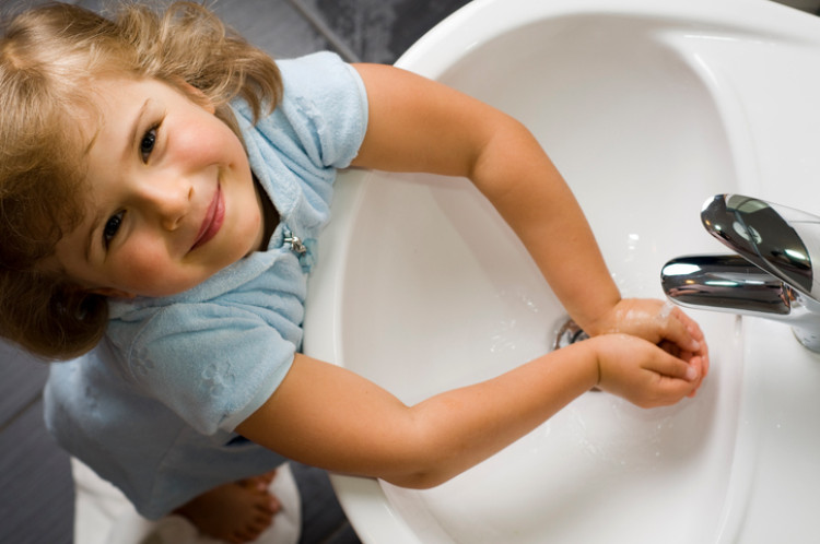 la bambina si lava le mani con l'acqua pulita del lavandino