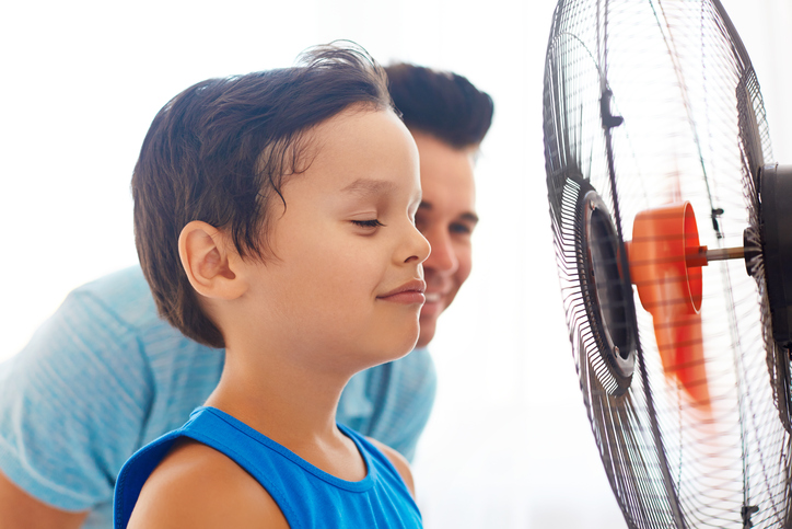 Un ragazzo e suo padre davanti a un ventilatore