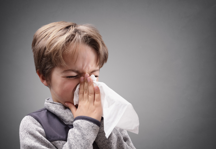 Il ragazzo si soffia il naso, con il catarro, in un fazzoletto sanitario.