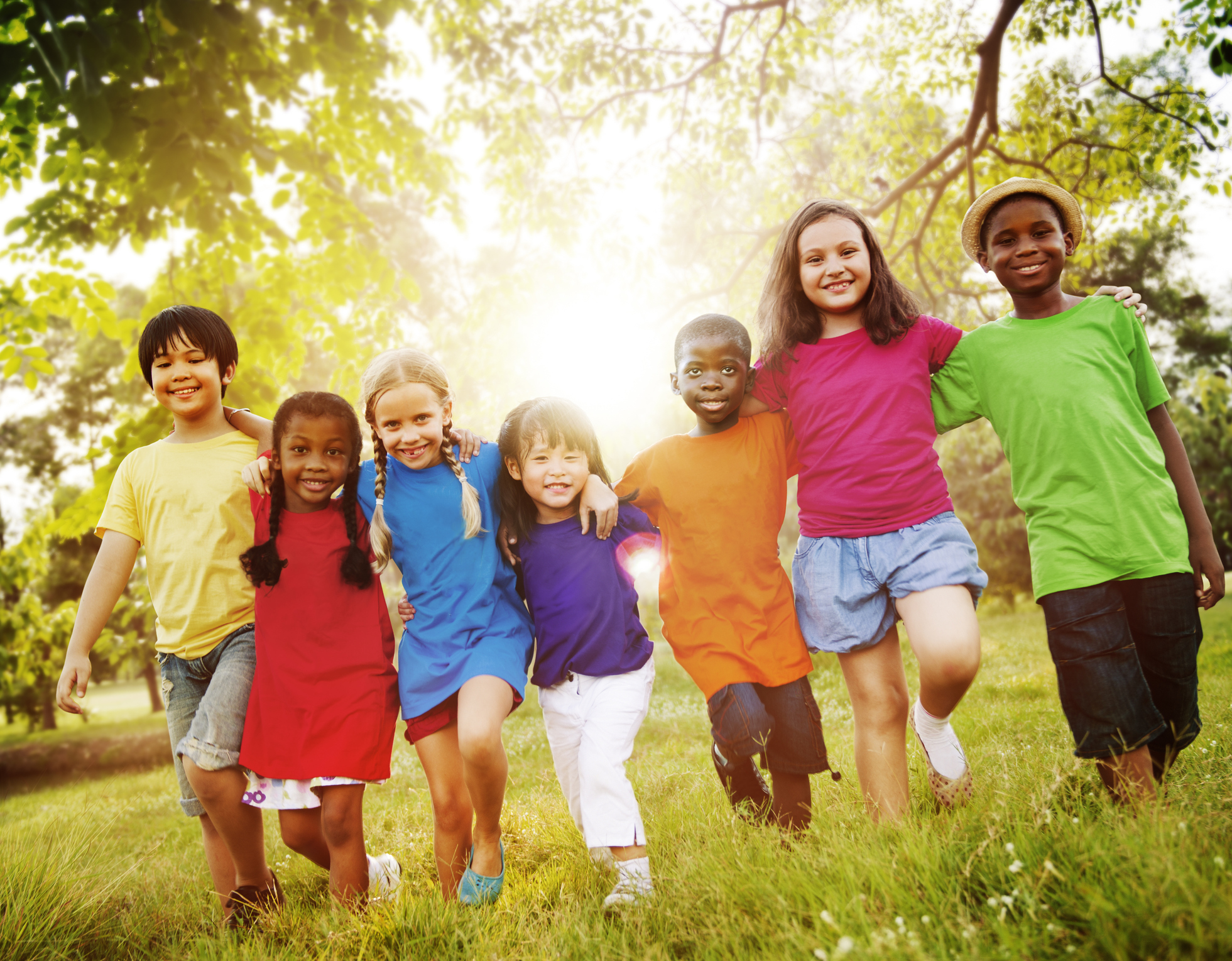 Bambini allegri nella natura, 7 bambini che si tengono per le spalle, erba, alberi