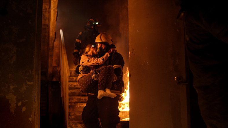 incendio in casa, i pompieri portano fuori il bambino in braccio