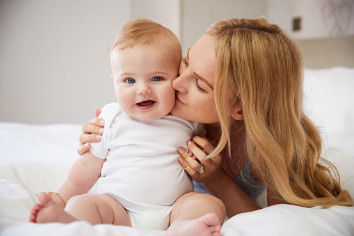 madre che bacia il suo bambino felice