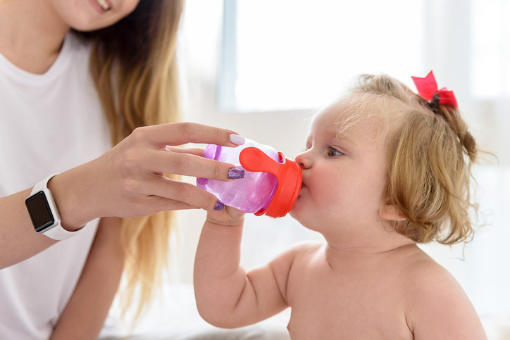 La madre dà da bere acqua pulita alla bambina