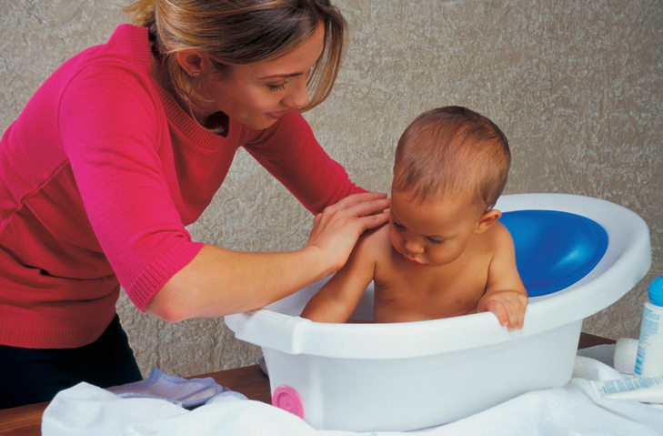 Madre che fa il bagno al bambino nella vasca da bagno