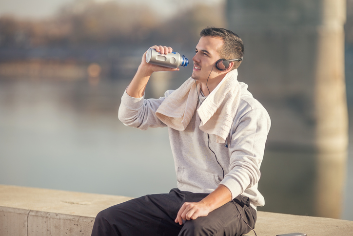 Un atleta beve acqua da una bottiglia