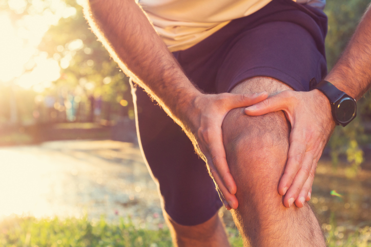 atleta maschio che si tiene il ginocchio dolorante