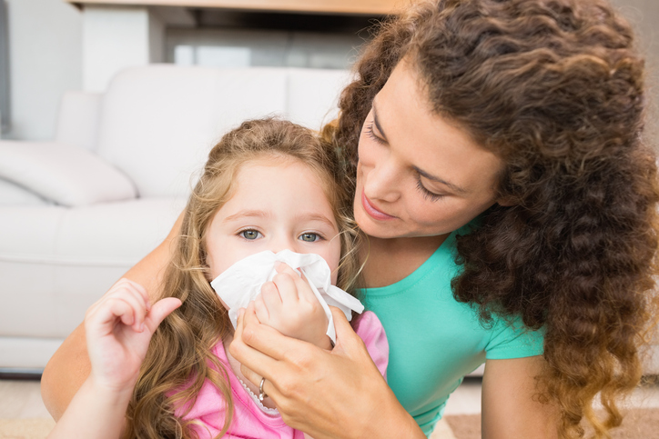 Il bambino ha il naso che cola, la madre gli soffia il naso pieno di secrezioni, un naso pieno per le allergie