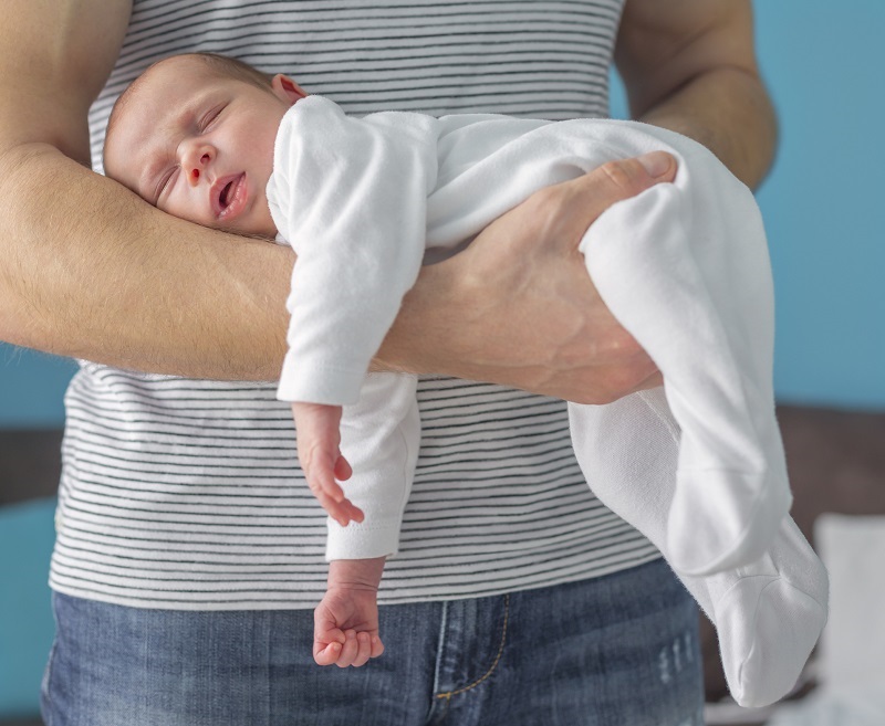 Il padre e il suo bambino nell'immagine dimostrano una posizione adatta a facilitare il passaggio dei gas.