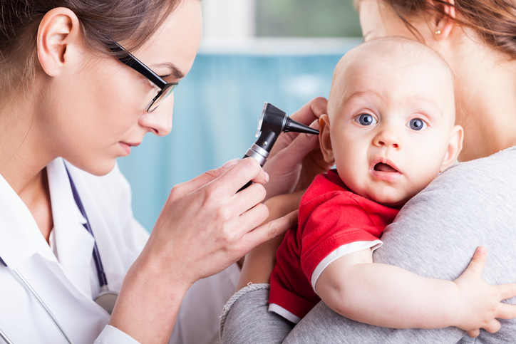 un medico esamina l'orecchio di un bambino con una macchina