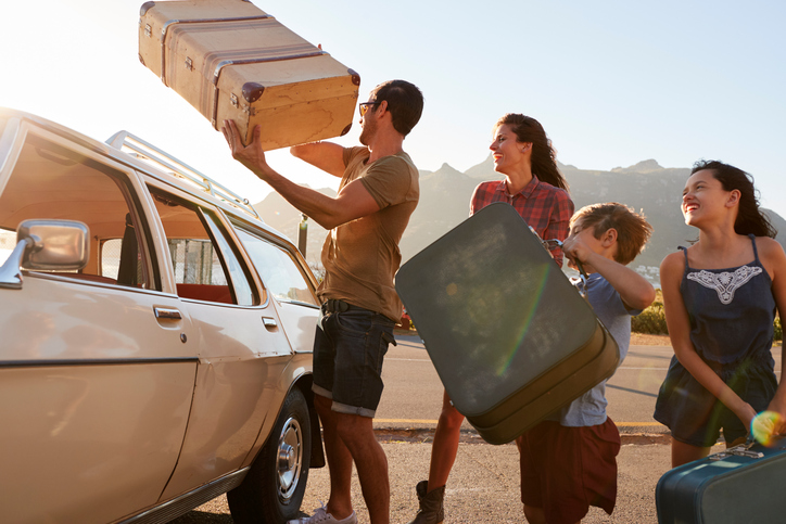 famiglia che prepara le valigie in macchina prima di una vacanza