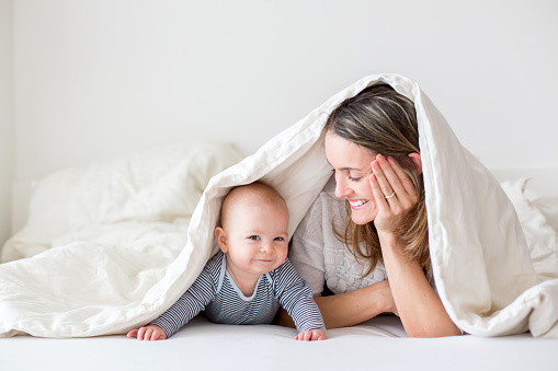 Bambino ridente con la madre sotto il palanchino