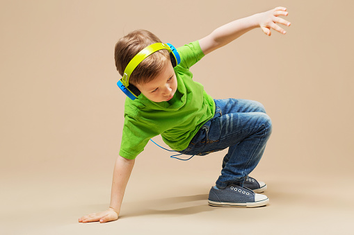 Un ragazzo in camicia verde con le cuffie fa la break dance