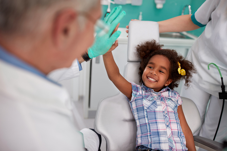 la ragazza che ride sulla poltrona del dentista con il dentista.