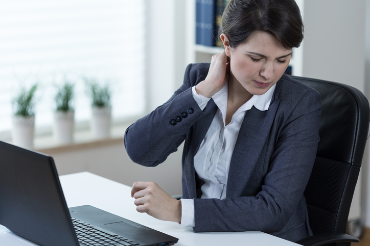 Una donna ha dolore al rachide cervicale per il lavoro prolungato al computer e la seduta prolungata