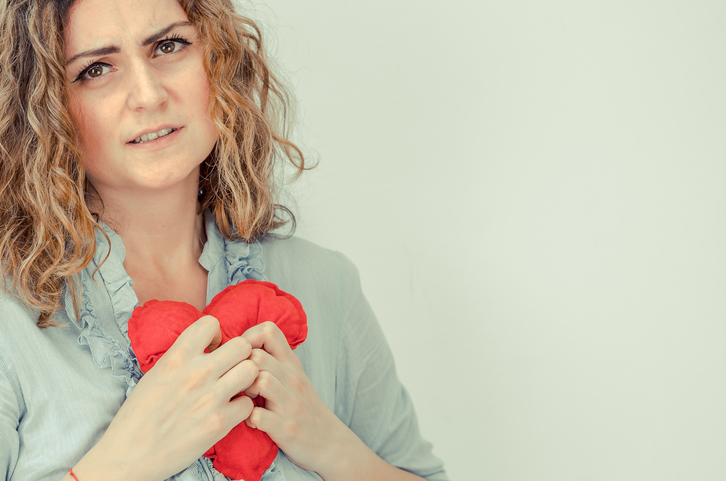 donna che tiene in mano un cuore di peluche rosso