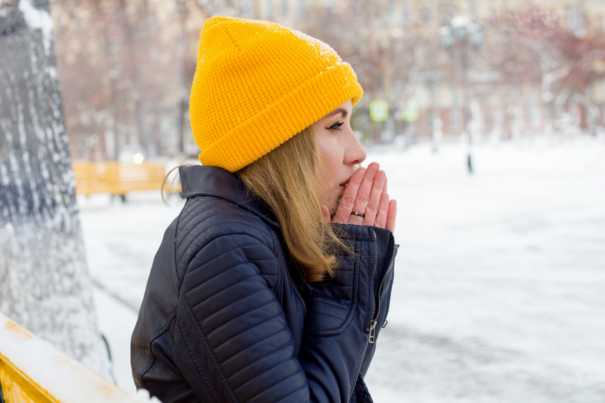 Una giovane donna che espone le mani al freddo.