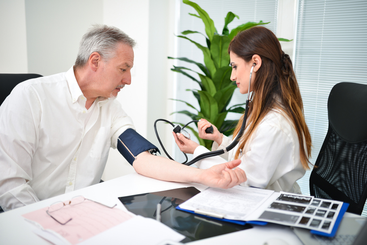 Un medico misura la pressione sanguigna di un uomo