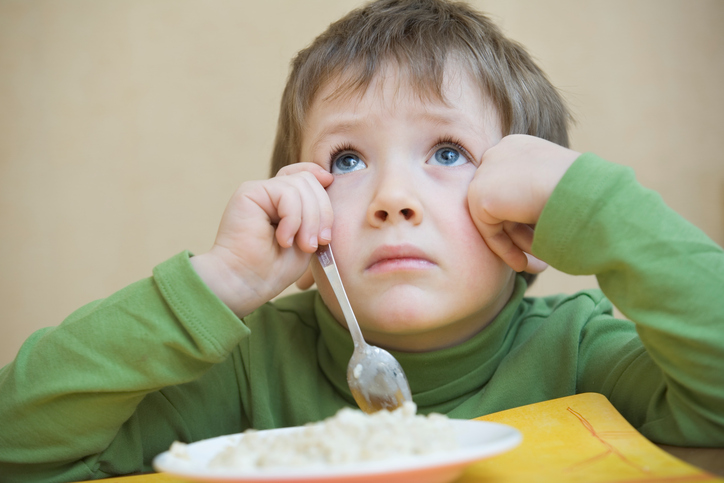 Il bambino si siede sopra il piatto, non vuole mangiare, ha un disturbo della deglutizione dovuto a un'infiammazione del cavo orale.