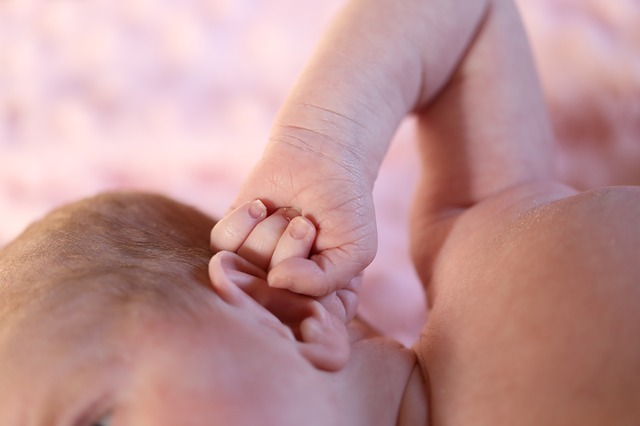 un bambino piccolo (toddler) si tiene l'orecchio con la mano