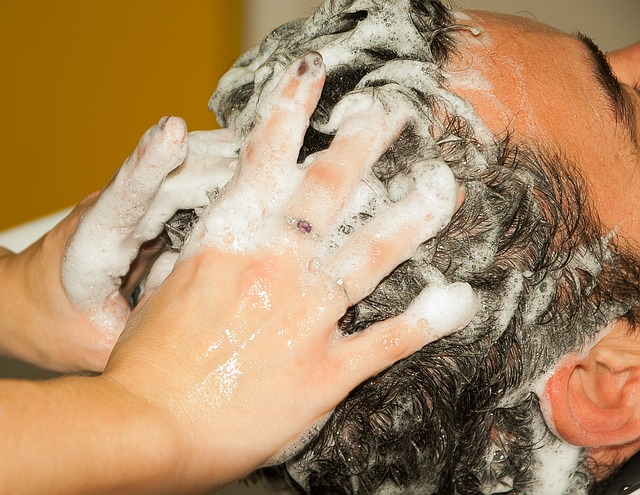 gli uomini si lavano i capelli e si fanno fare lo shampoo in testa, con le mani nei capelli