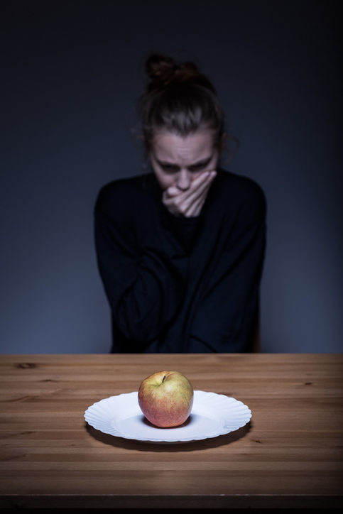 Donna rifiuta il cibo, c'è una mela nel piatto, disgustoso