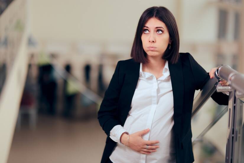 Una donna incinta stanca dopo aver salito le scale. Fonte: Getty Images